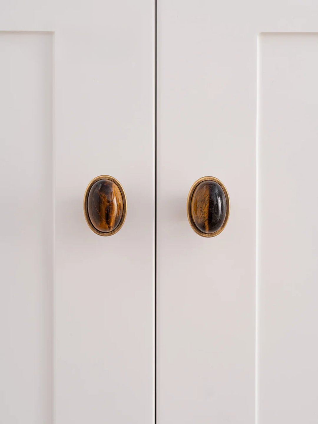 Close-up of a white cabinet with wooden knobs