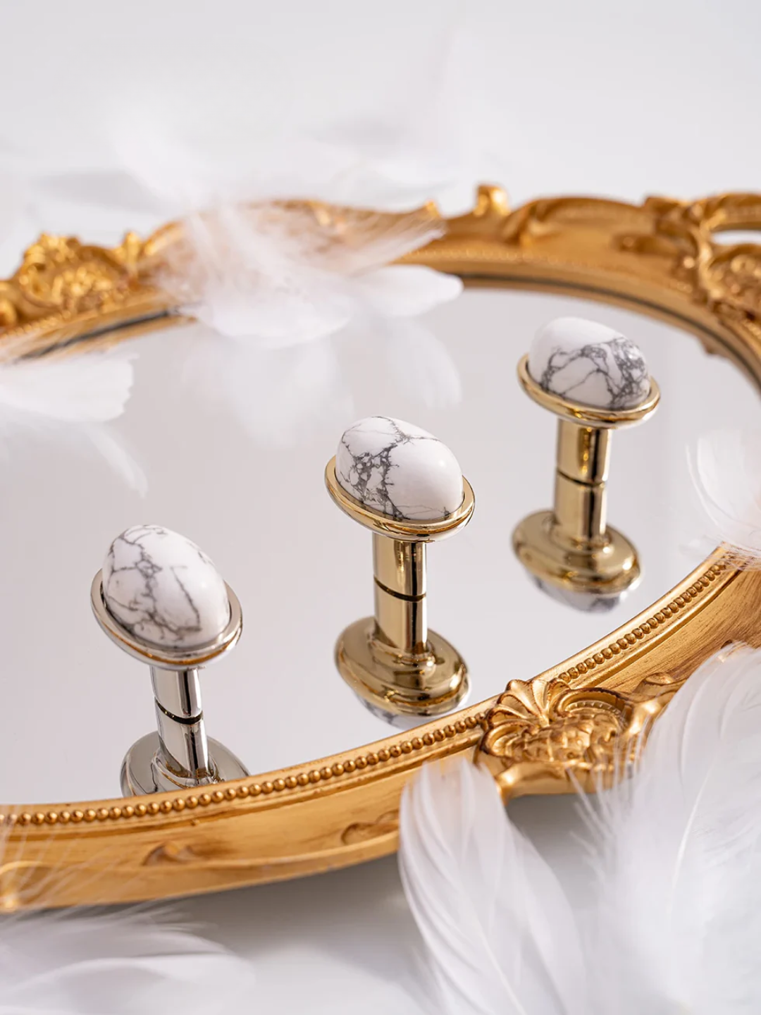 Gold and marble door handles on a decorative mirror with 'Santaya' branding.