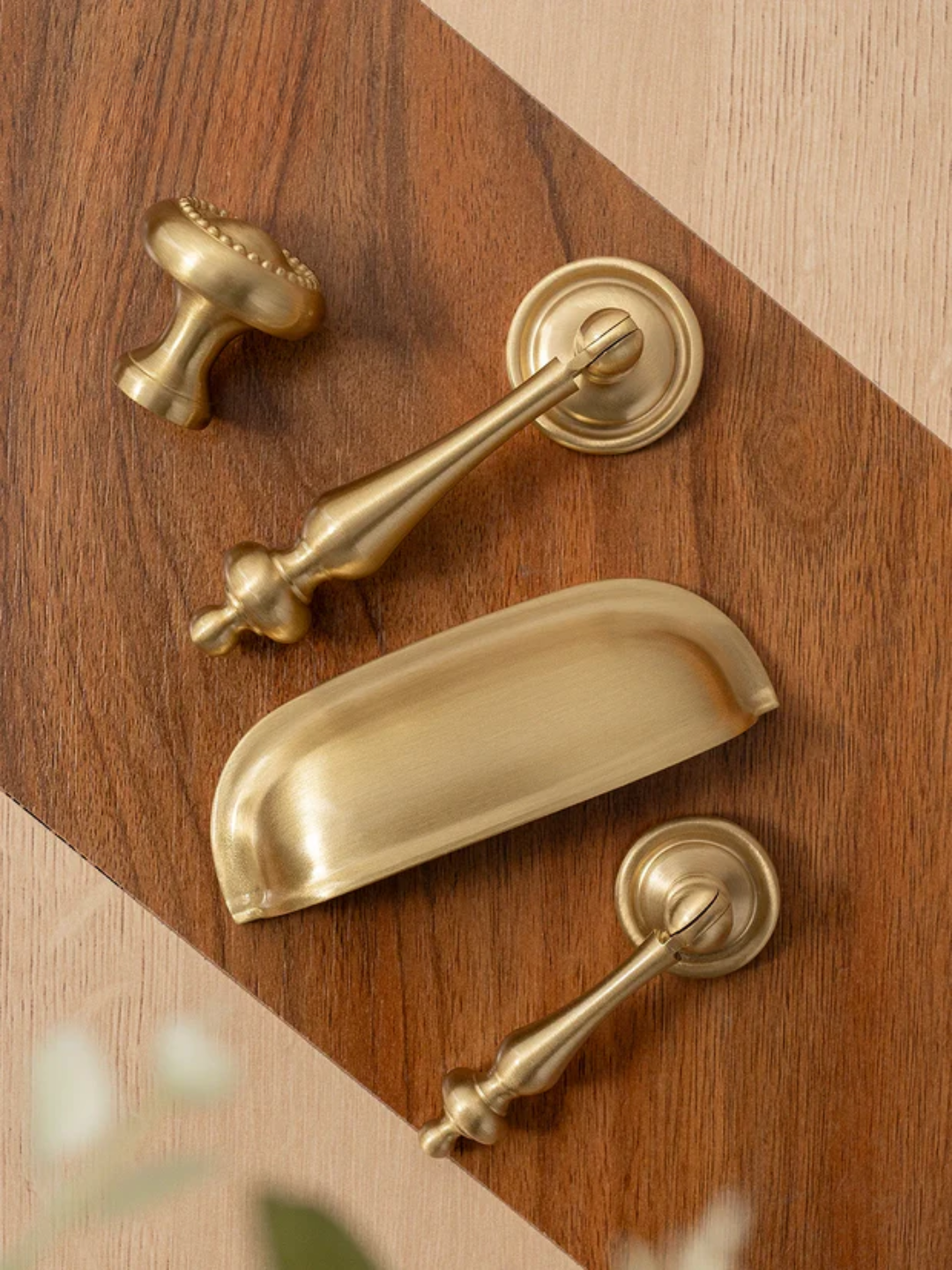 Set of gold door handles and hardware on a wooden surface