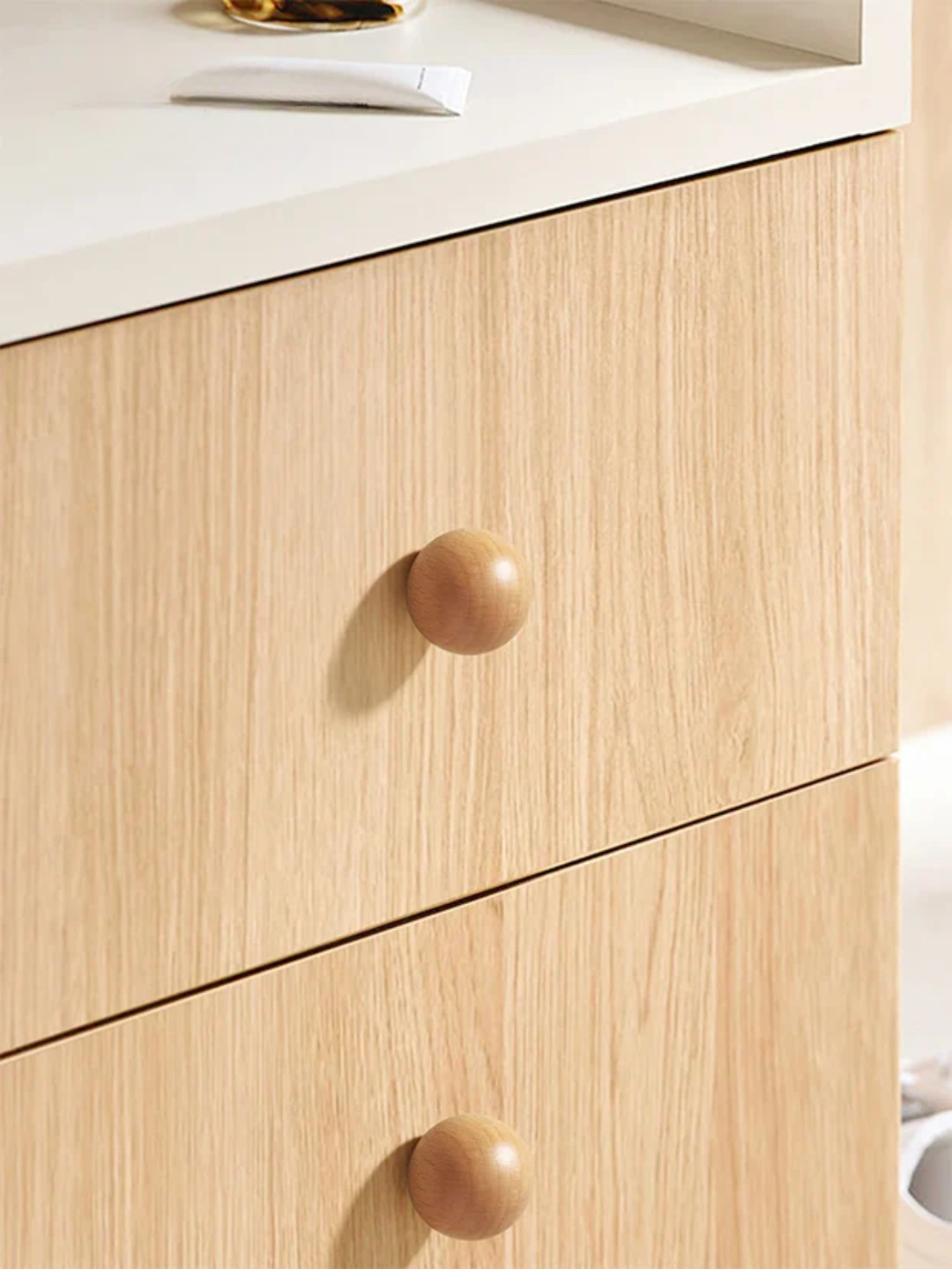 Wooden cabinet with round knobs on a white countertop