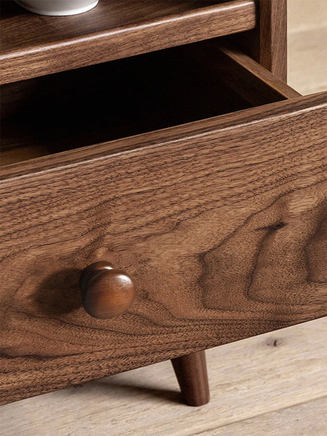 Close-up of a wooden drawer with a knob on a wooden surface