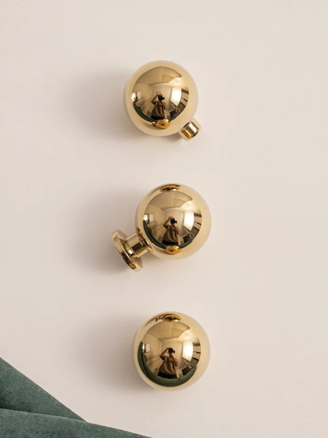 Three gold knobs on a beige background.