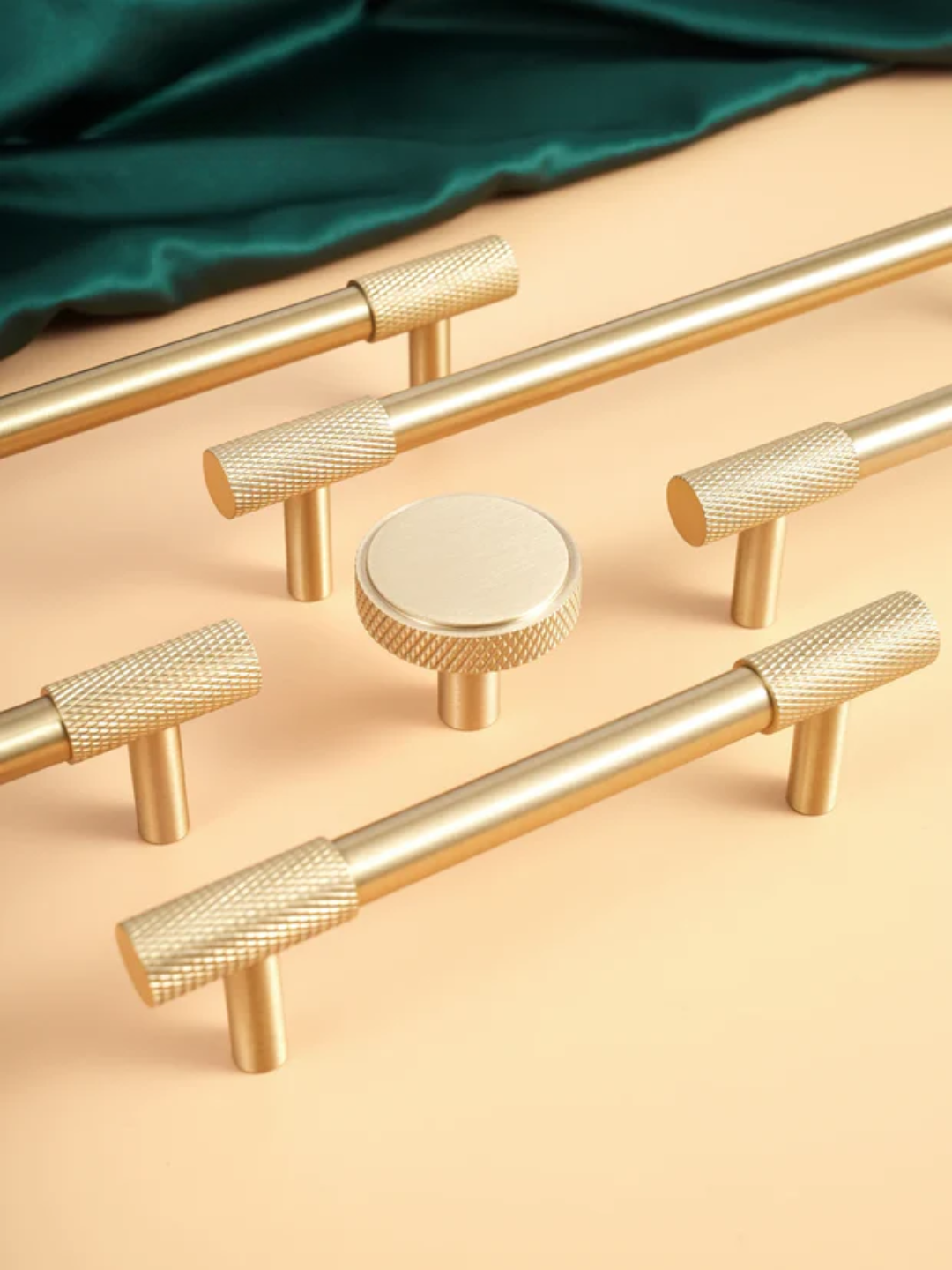 Set of gold cabinet handles and knobs on a beige background