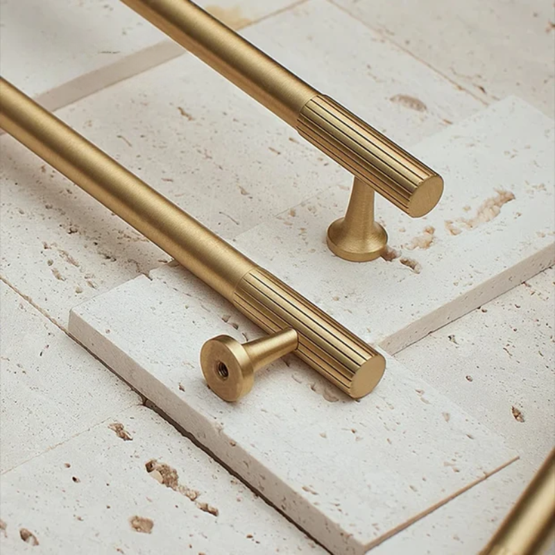 Gold cabinet handles on a light stone surface
