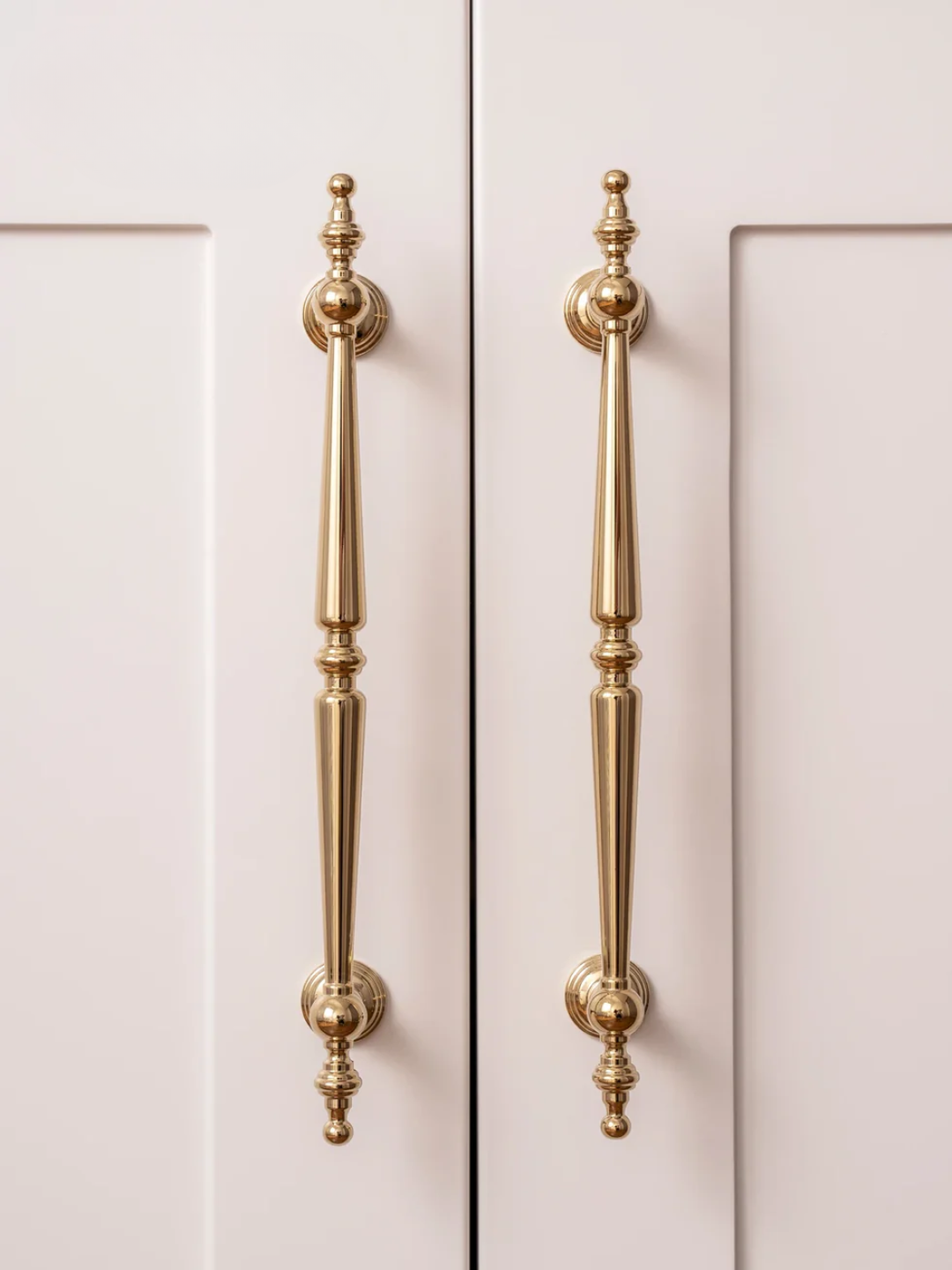 Gold cabinet handles on a white cabinet door