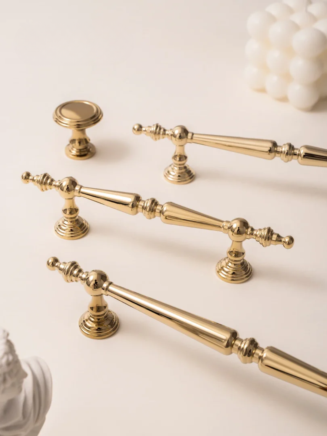 Set of gold cabinet handles and knobs on a light background