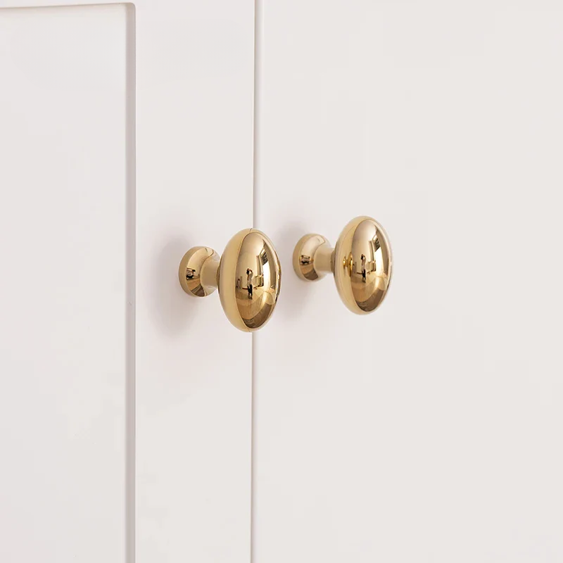 Gold cabinet knobs on a white door