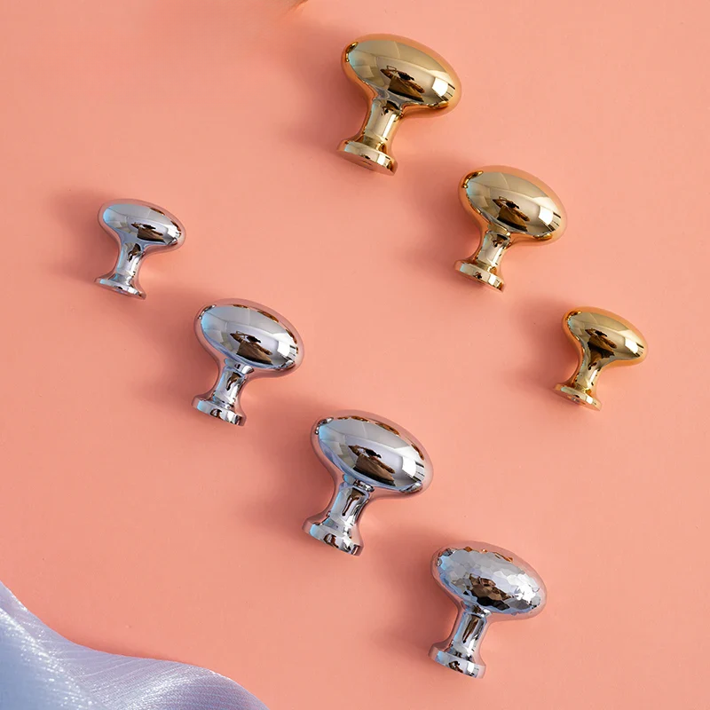 Gold and silver cabinet knobs on a peach background