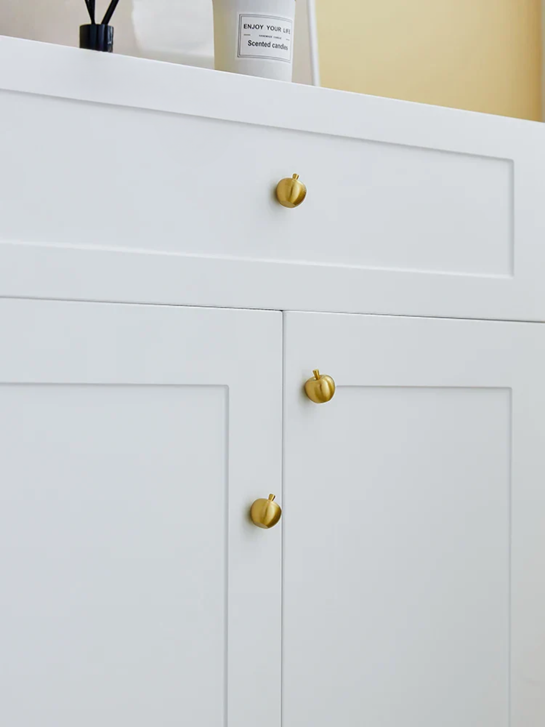 White cabinet with gold knobs on a neutral background