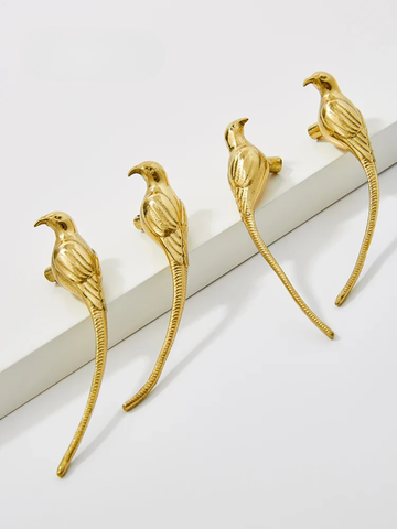 Gold bird-shaped earrings on a white surface