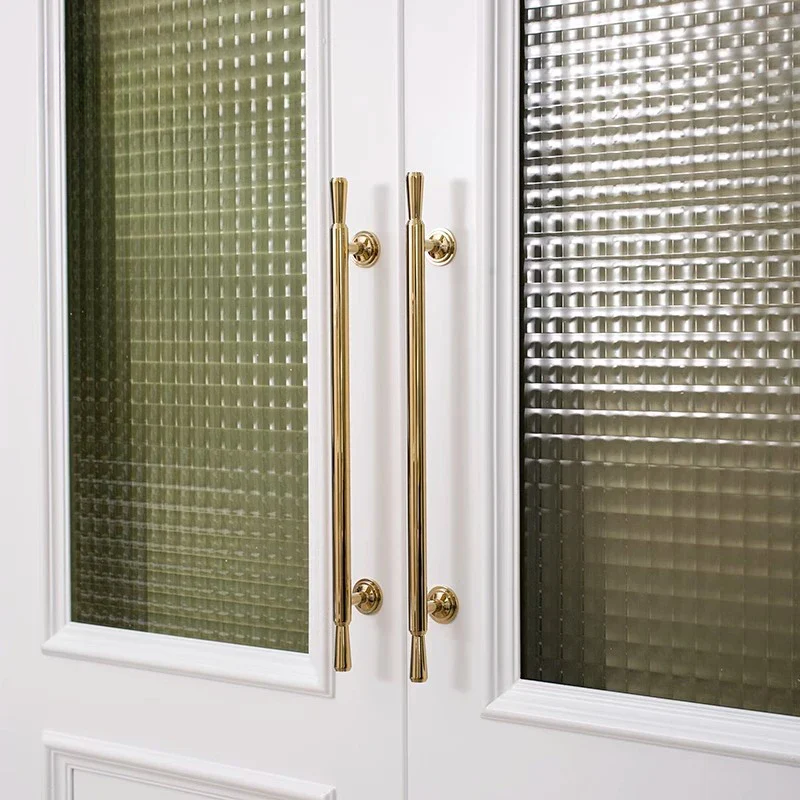 White cabinet with gold handles and textured glass doors.