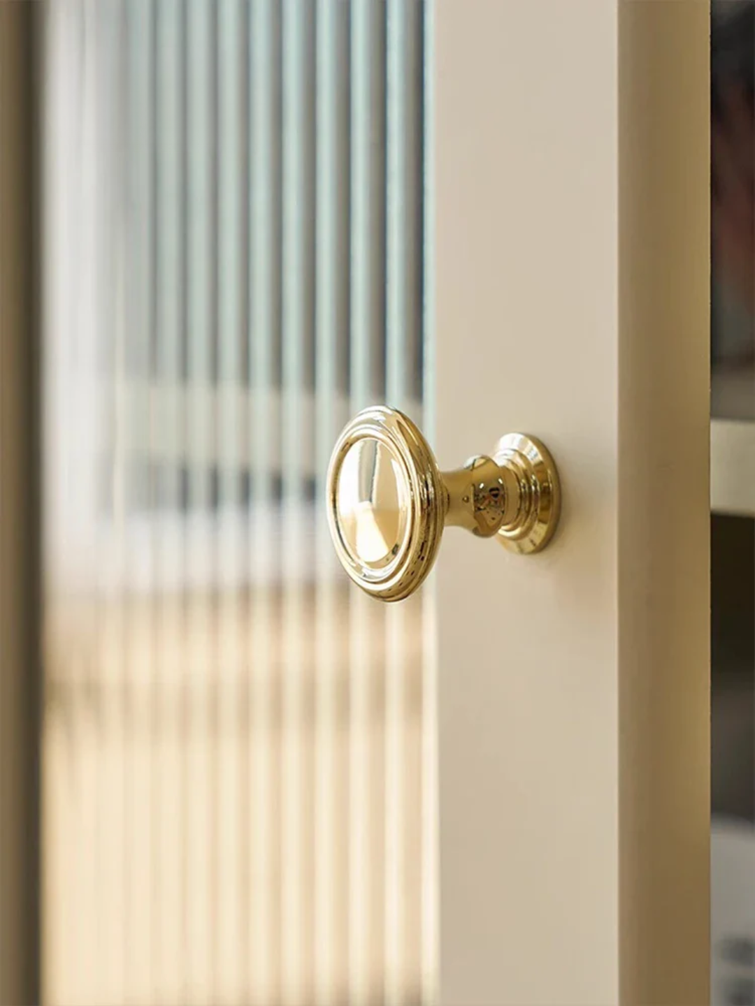Gold door handle on a glass door with blurred background