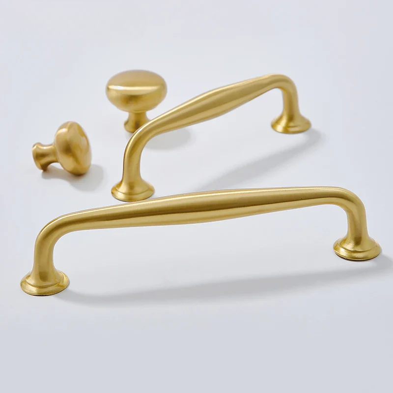 Set of gold cabinet handles on a light gray background