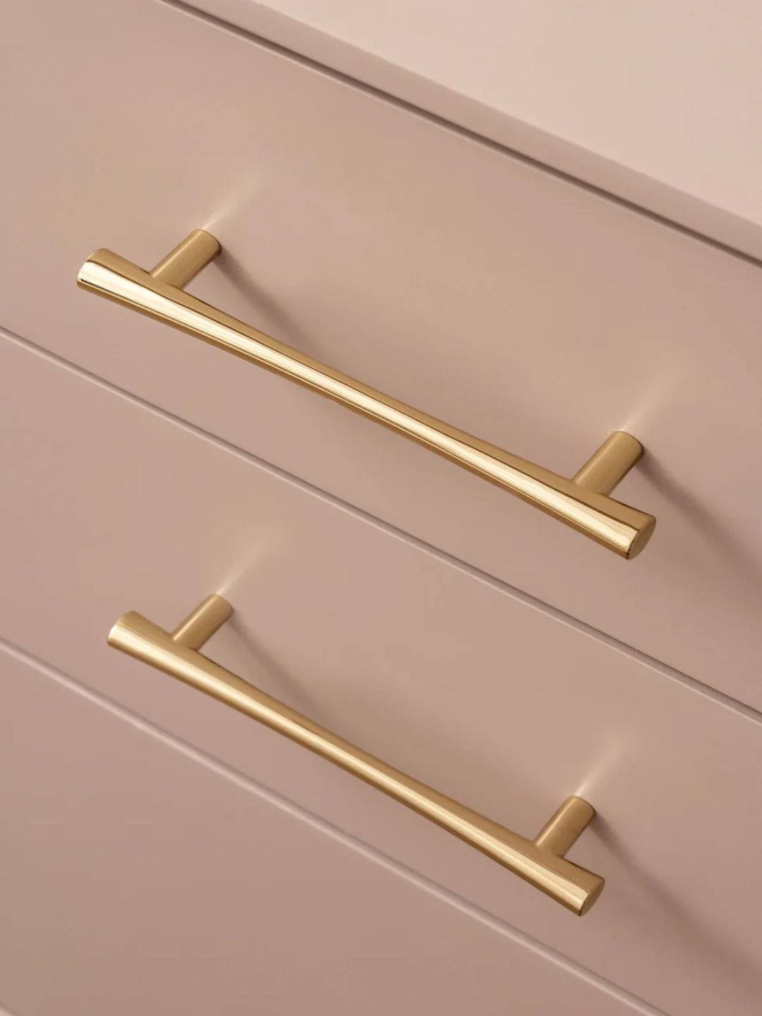 Gold cabinet handles on a beige cabinet