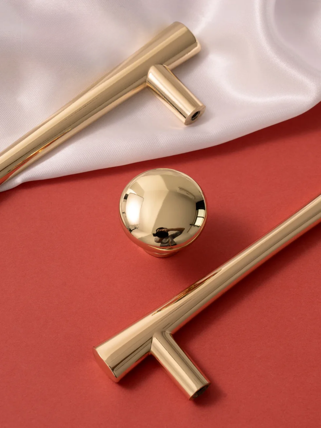 Gold cabinet handles on a red and white background