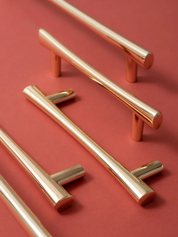 Rose gold cabinet handles on a red background