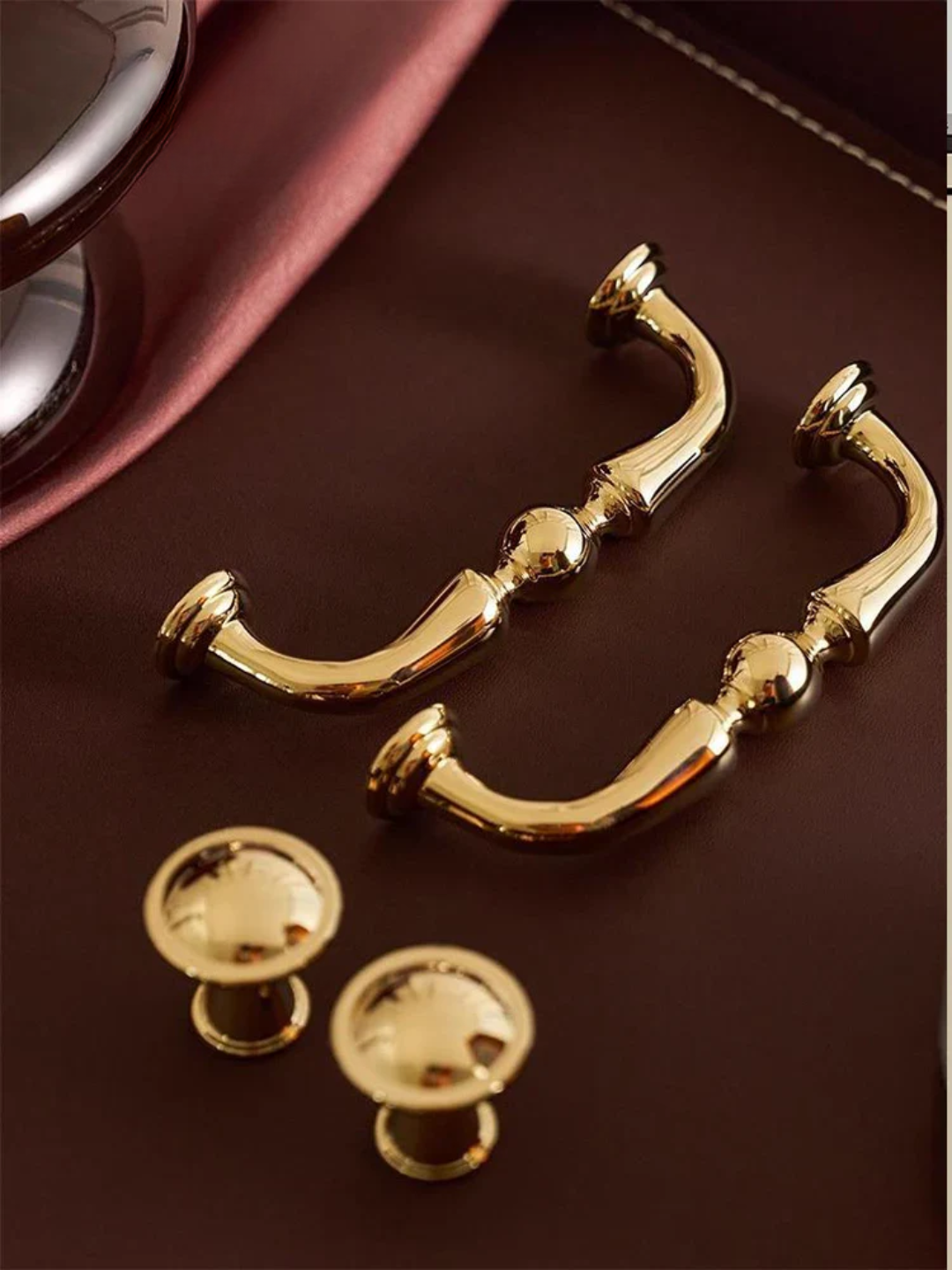 Gold cabinet handles on a brown surface