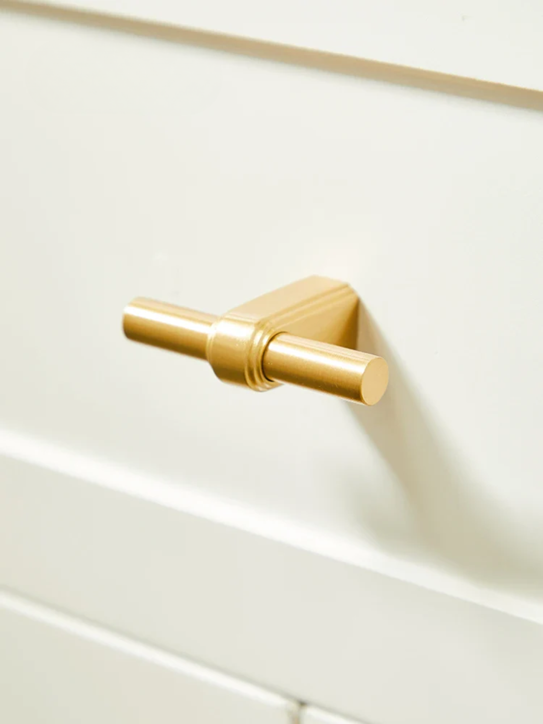 Gold handle on a white cabinet