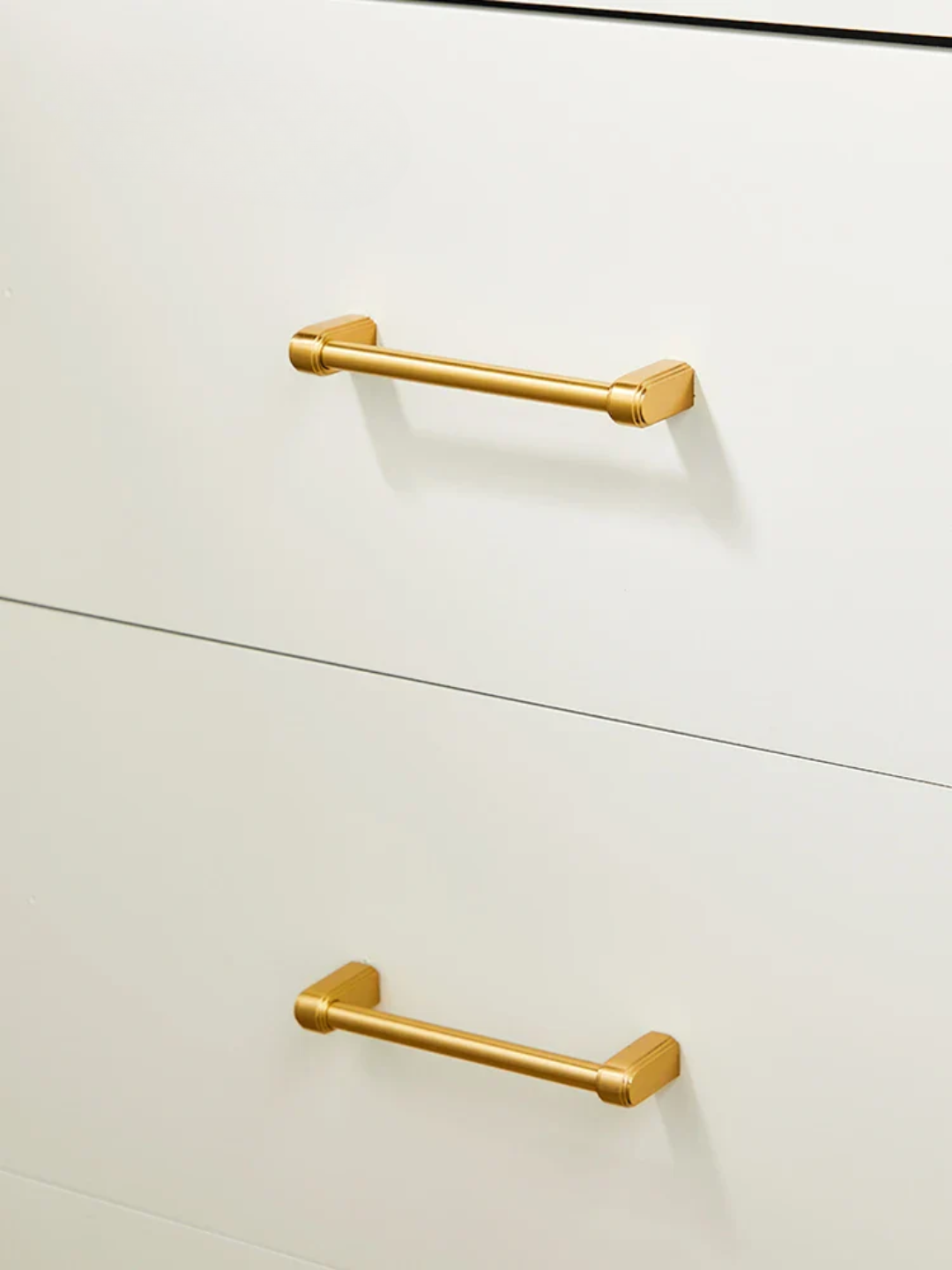 Gold cabinet handles on a white cabinet