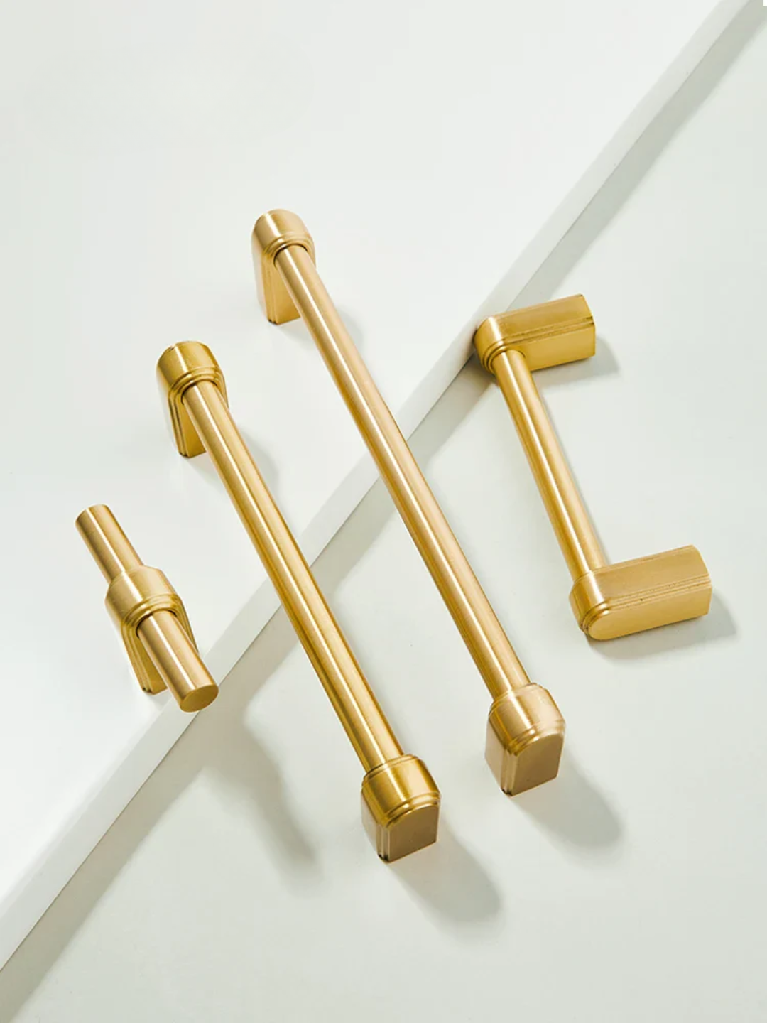 Set of gold cabinet handles on a white background