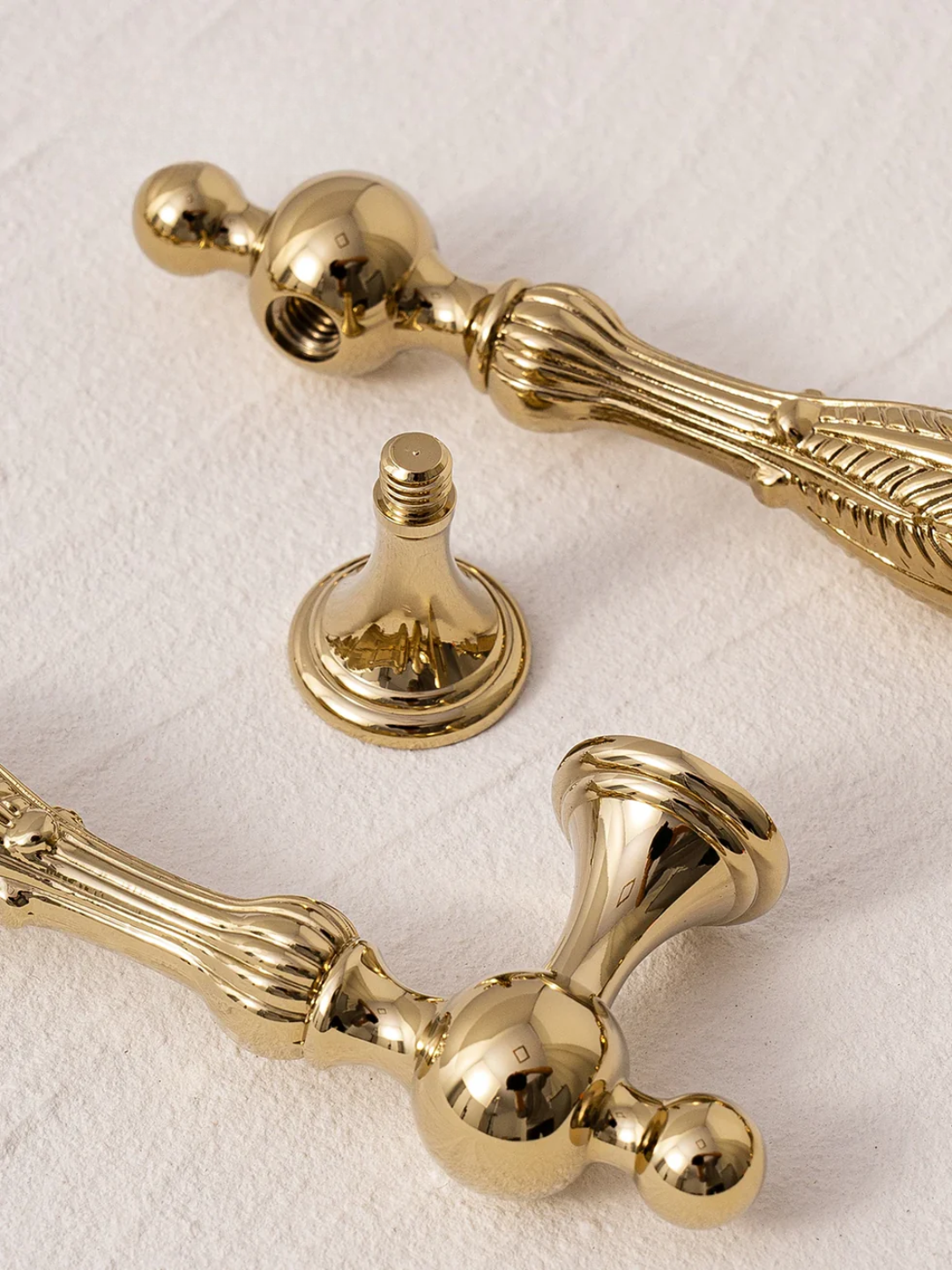 Gold decorative hardware pieces on a textured white surface with 'SANTAYA' branding.