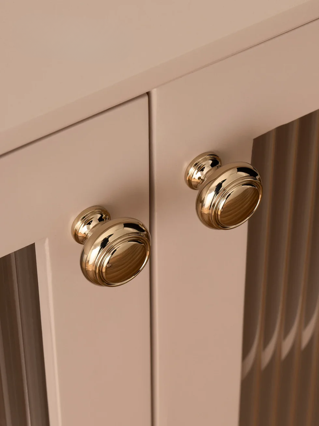 Close-up of a beige cabinet with gold handles