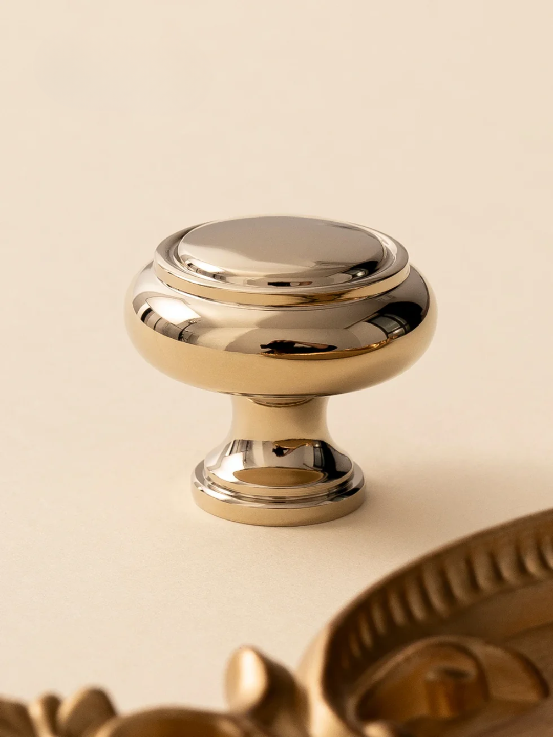 Gold cabinet knob on a beige background