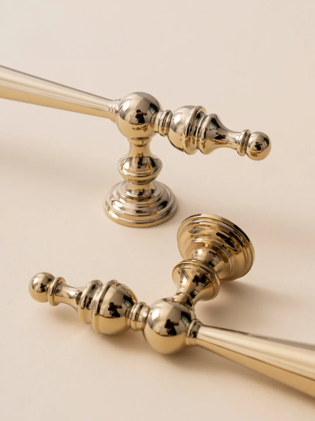 Close-up of gold bathroom fixtures on a beige background