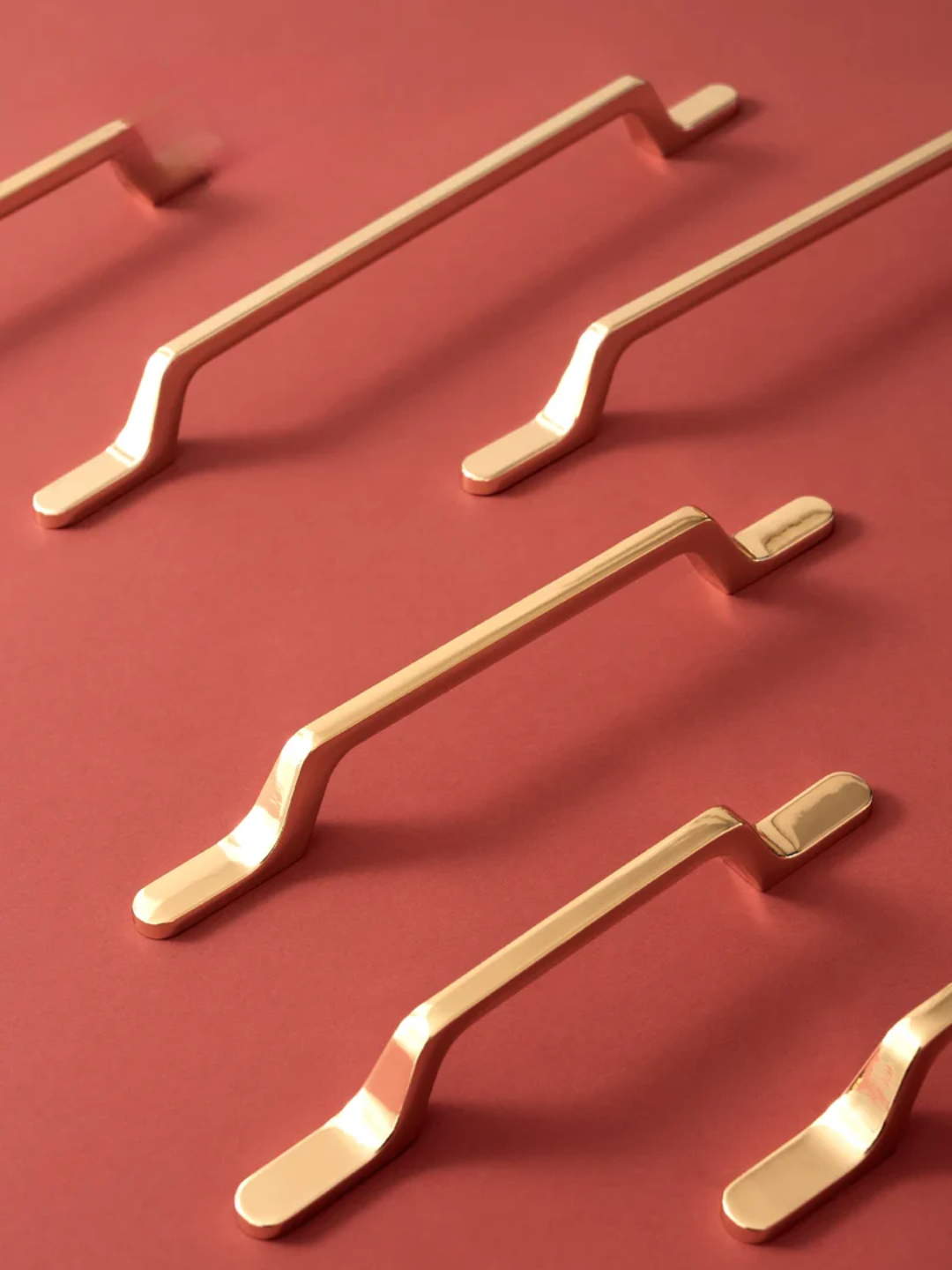 Set of gold cabinet handles on a red background