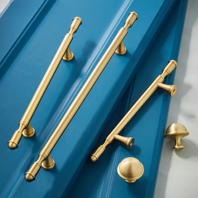 Gold cabinet handles on a blue cabinet door