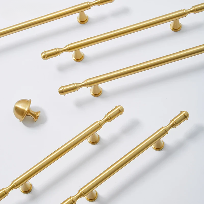 Gold cabinet handles on a white background
