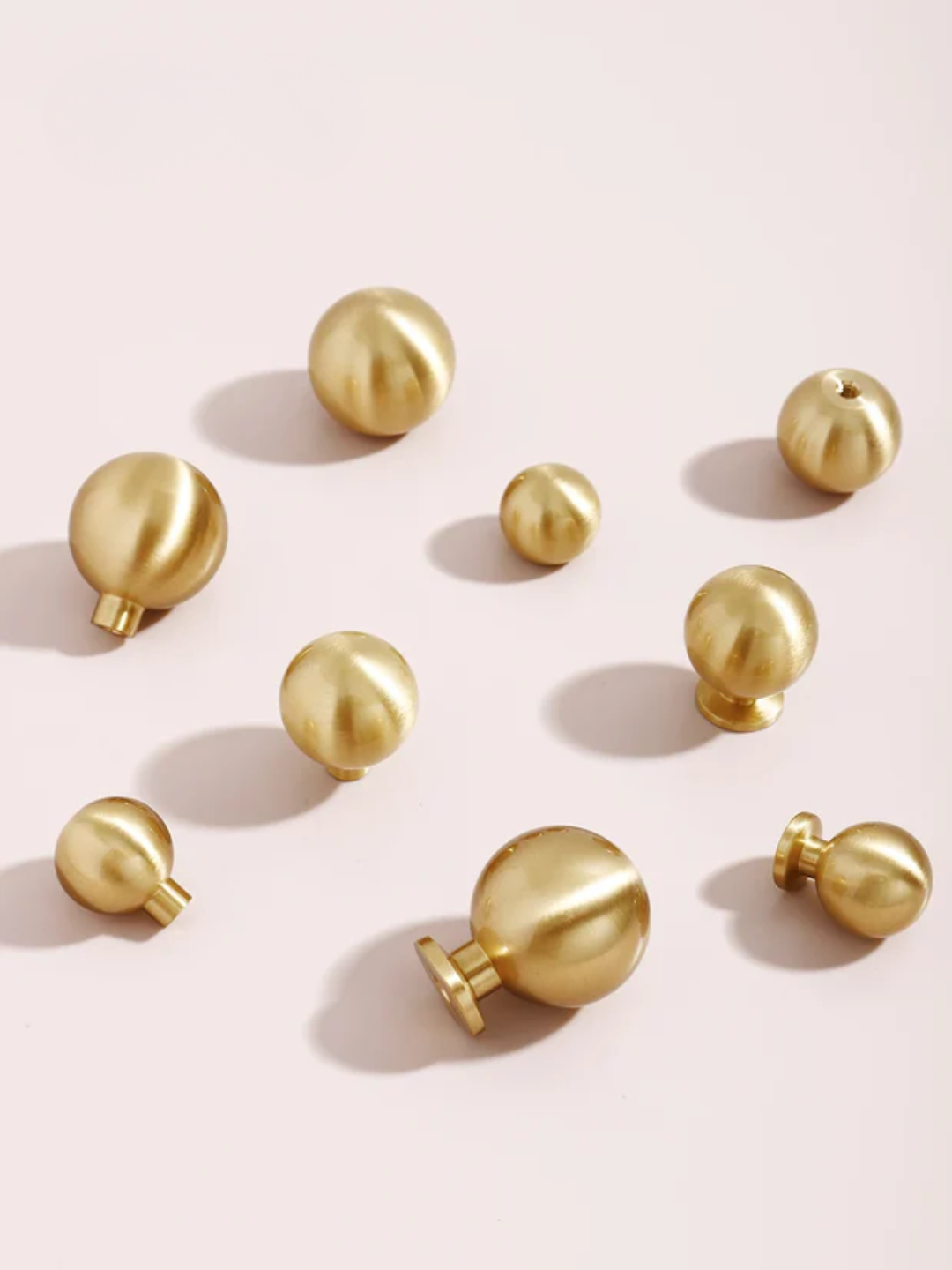 Gold spherical objects on a pink background