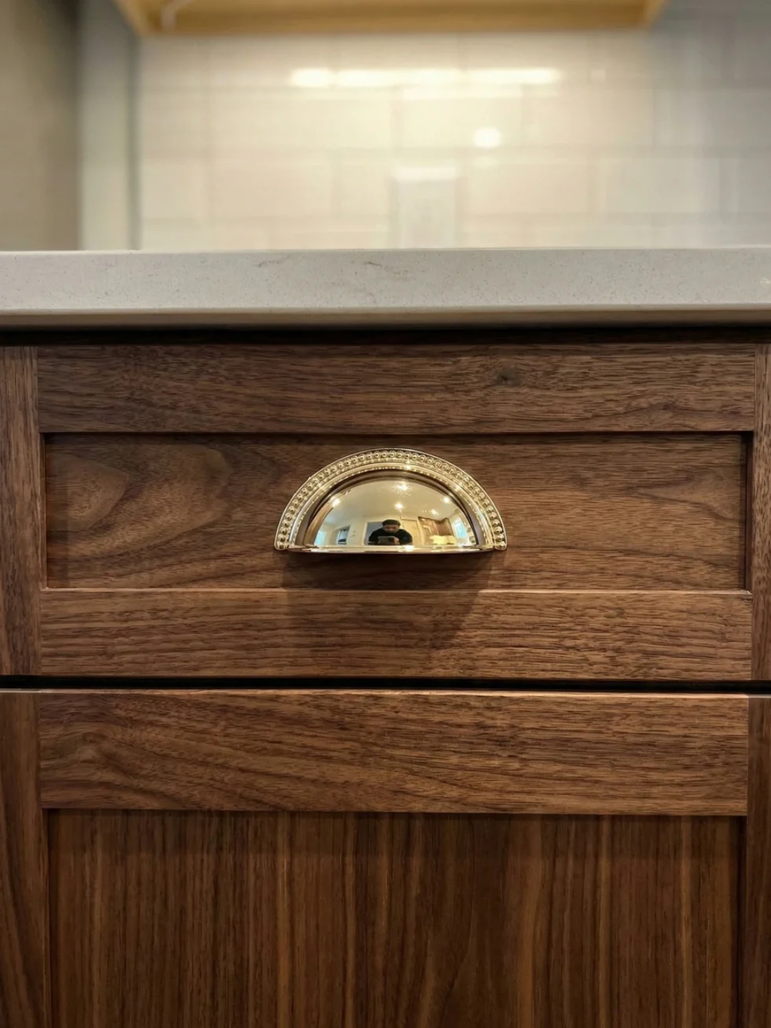 Wooden drawer with a gold handle in a kitchen setting