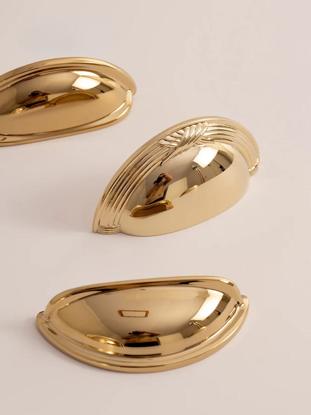 Gold cabinet knobs with 'Santaya' branding on a beige background