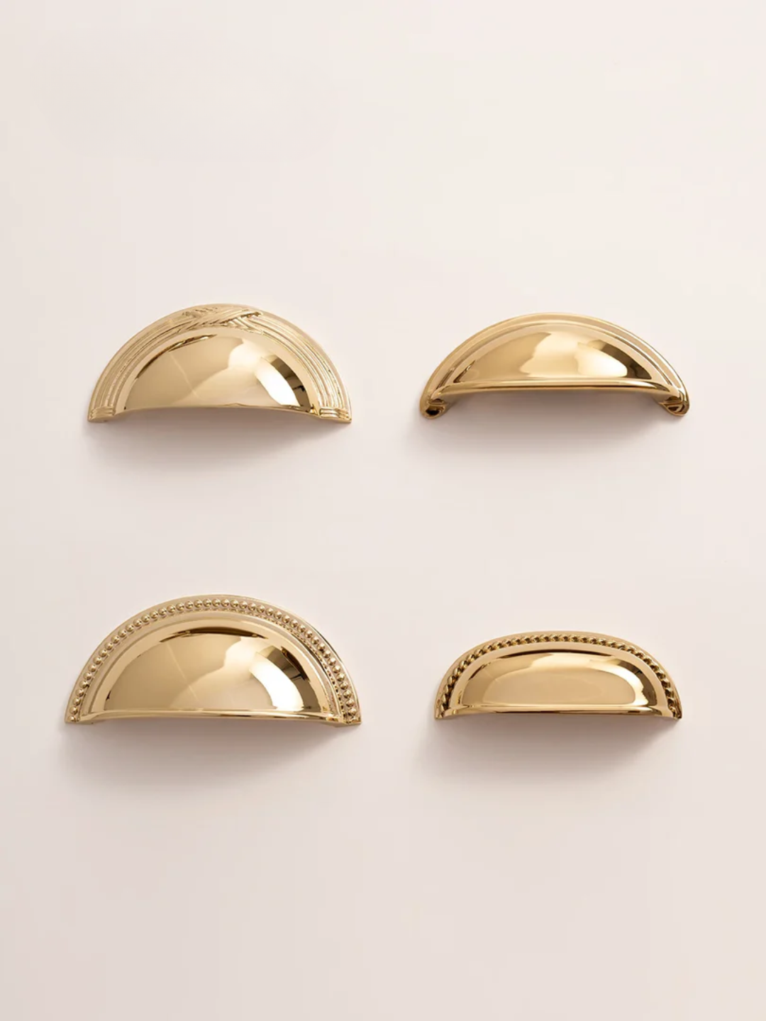 Four gold half-circle objects on a light beige background