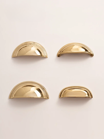 Four gold half-circle objects on a light beige background
