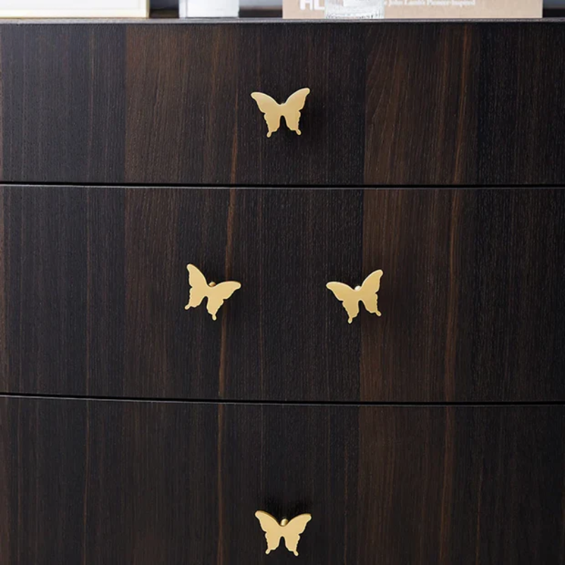 Dark wooden dresser with gold butterfly-shaped handles