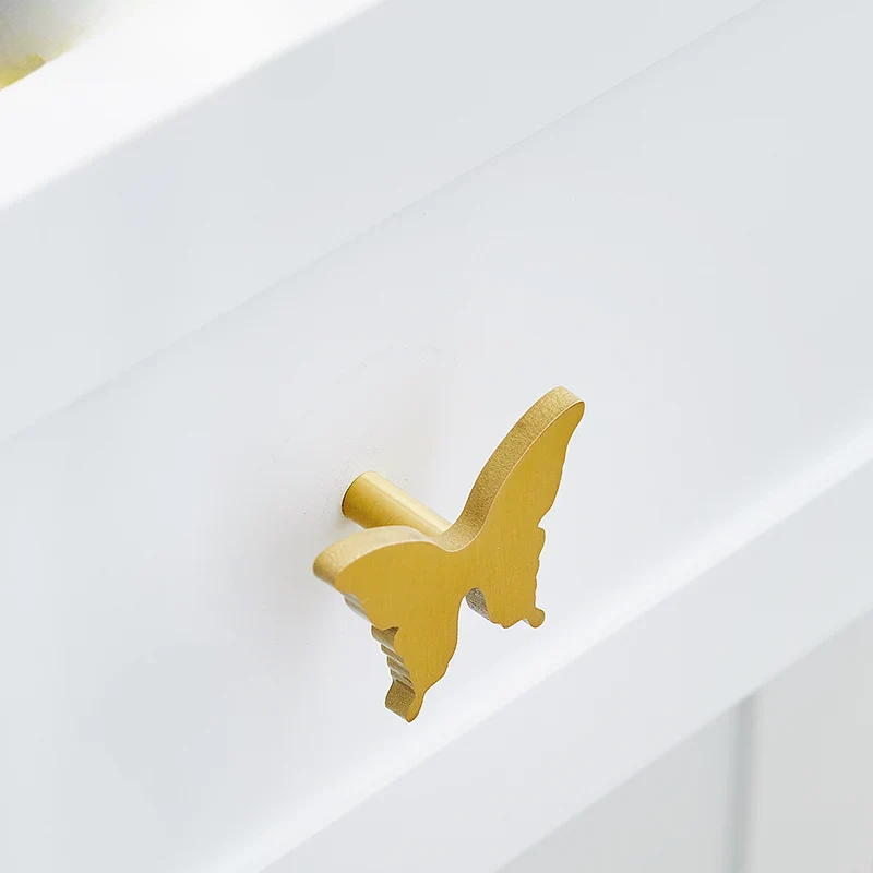Gold butterfly-shaped object on a white surface