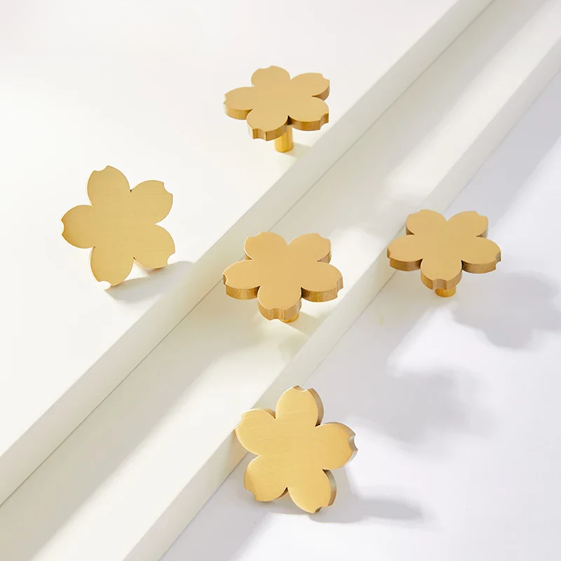 Gold flower-shaped knobs on a white surface