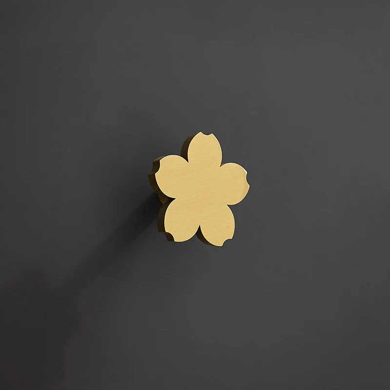 Gold flower-shaped knobs on a white surface