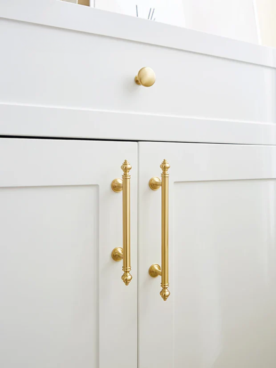 White cabinet with gold handles and knobs