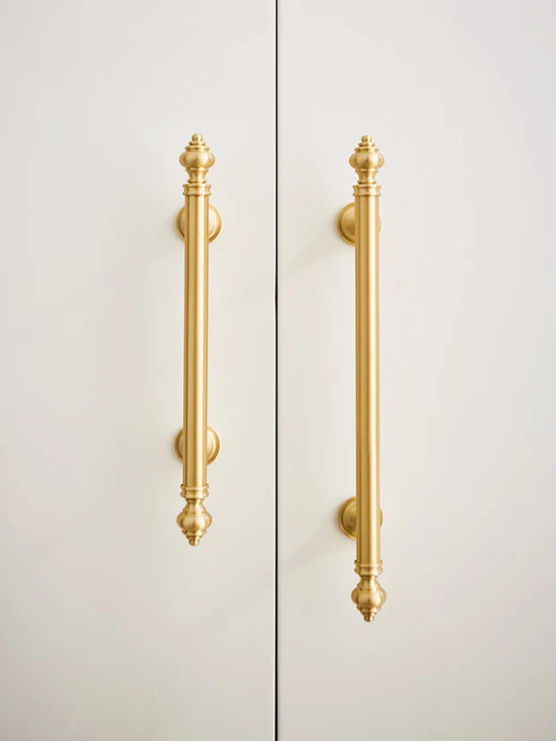 Gold cabinet handles and knobs on a white background