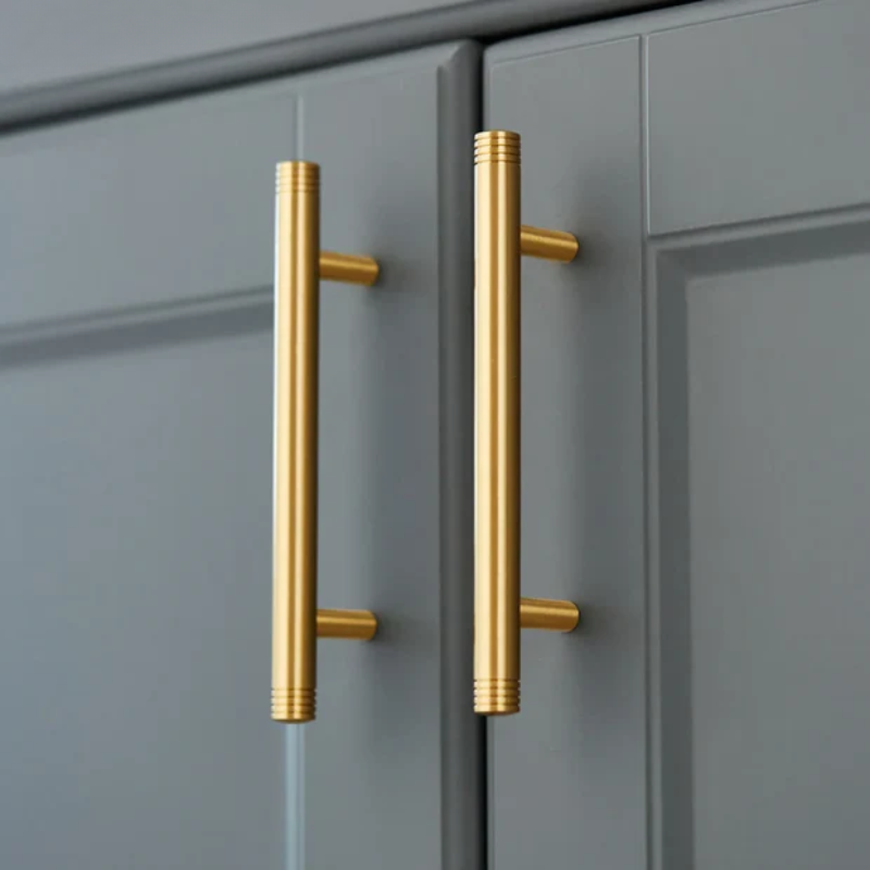 Gold cabinet handles on gray doors