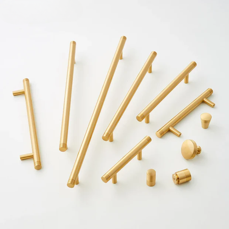 Set of gold cabinet handles and knobs on a white background