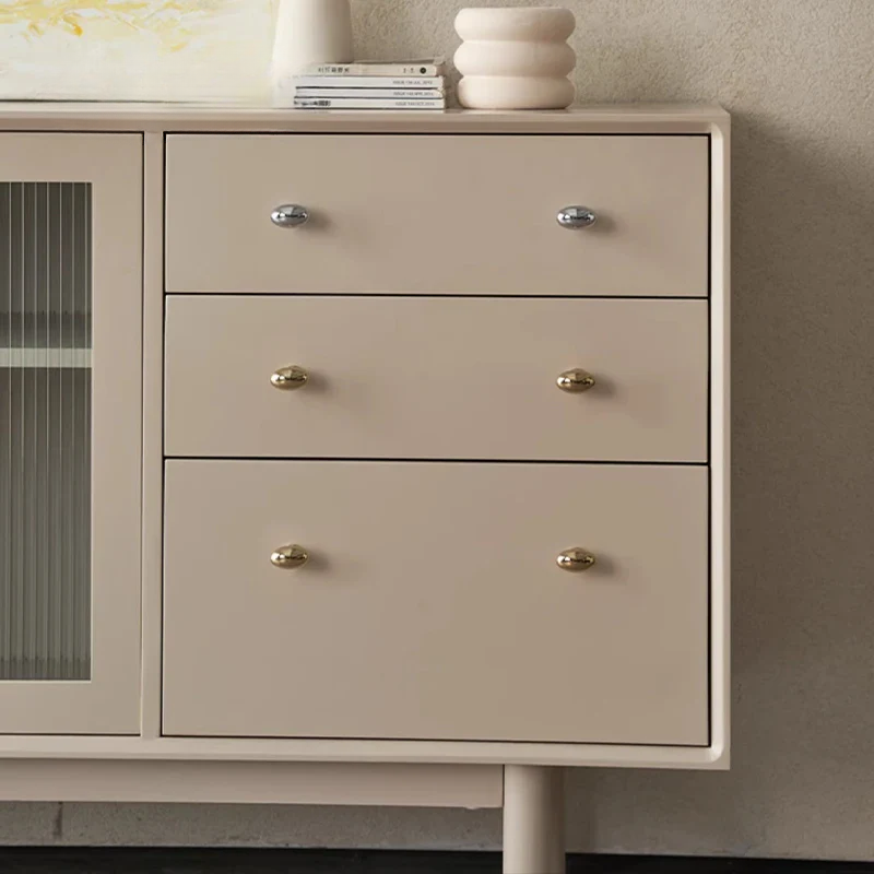 Beige dresser with three drawers and glass panels on a neutral background