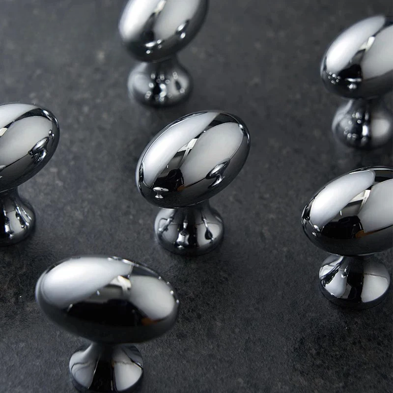 Chrome cabinet knobs on a dark surface