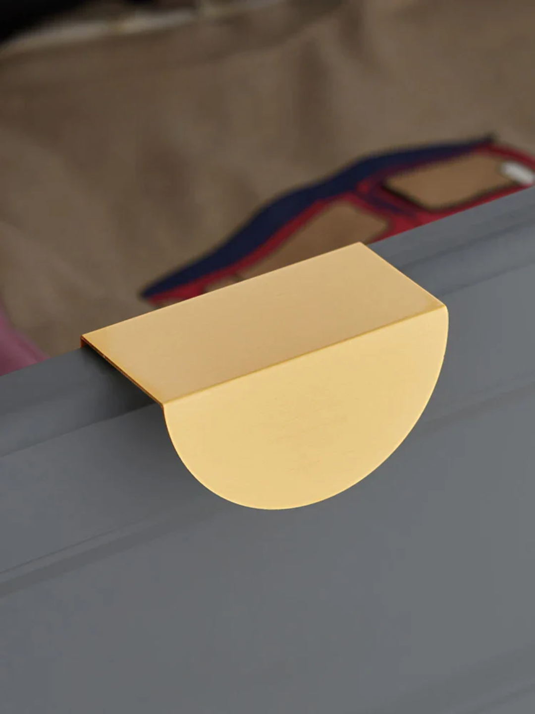 Gold suitcase handle on a gray suitcase with a blurred background