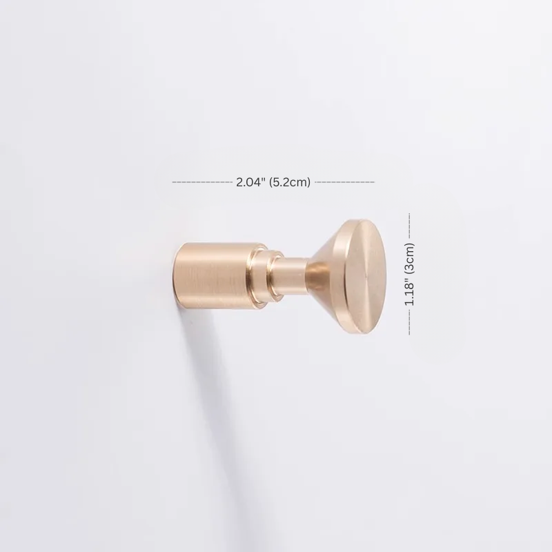 Gold door stopper with dimensions on a light gray background