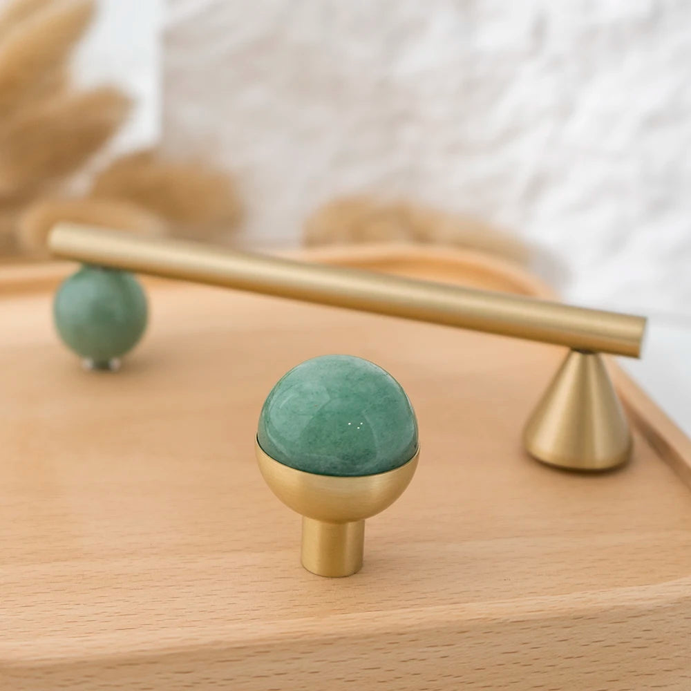Green decorative accent and brass cabinet knob with matching pull