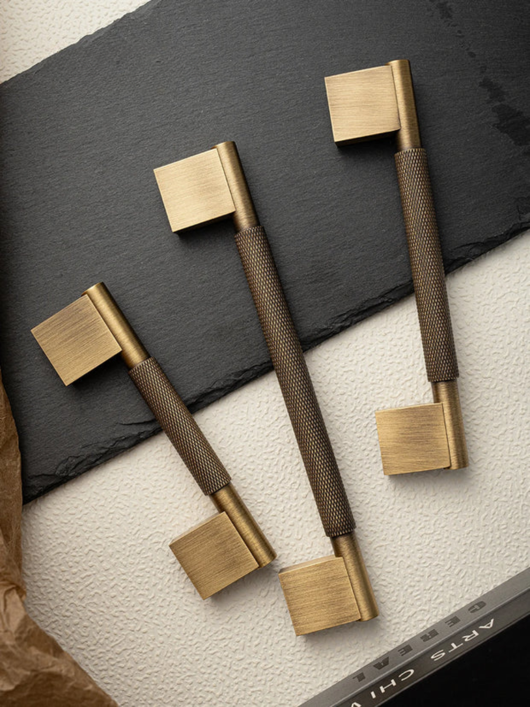 Brass and bronze handles on a dark surface